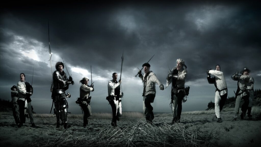 People standing with weapons on dark background