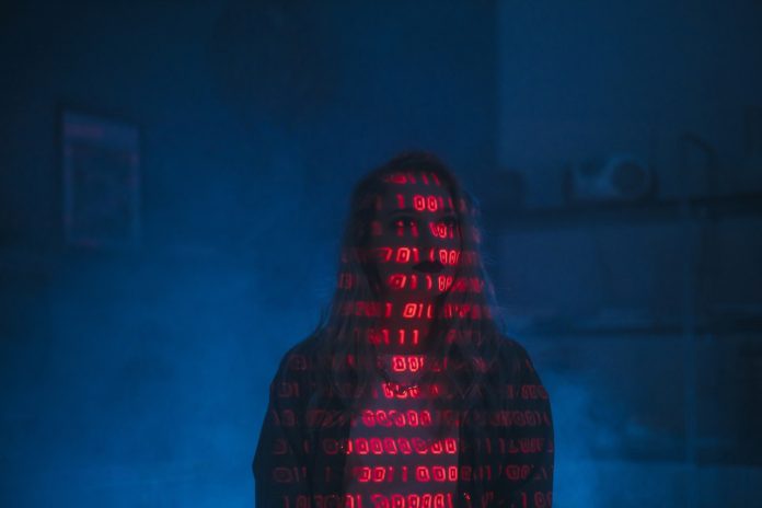 Person covered with binary code in blue background