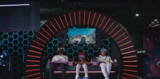 Three people siting in dome playing virtual reality game with virtual reality headset