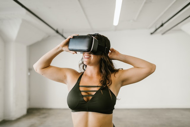 Woman in black sports top wearing virtual reality headset