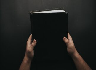 Black book the bible person holding in his hands