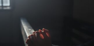 World without Religion? Person praying in church