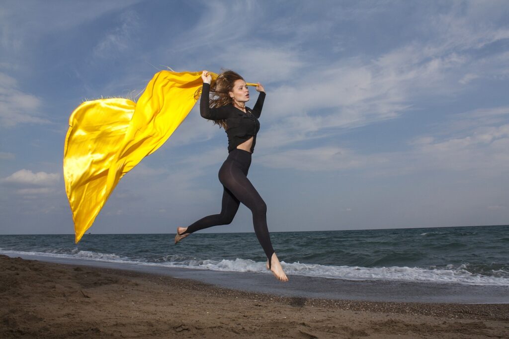 Woman running with yellow cape