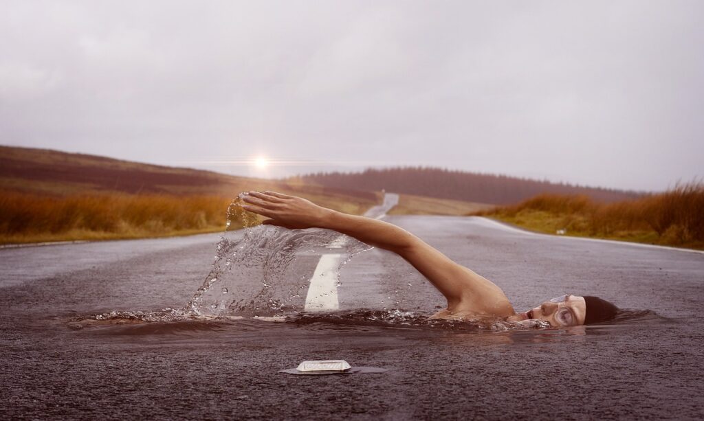 Human swimming on the road in middle of desert