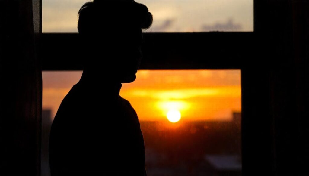 Person in dark standing by the window